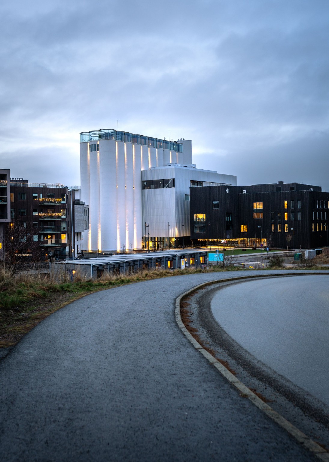 Curved modern building and pedestrian passage at dusk